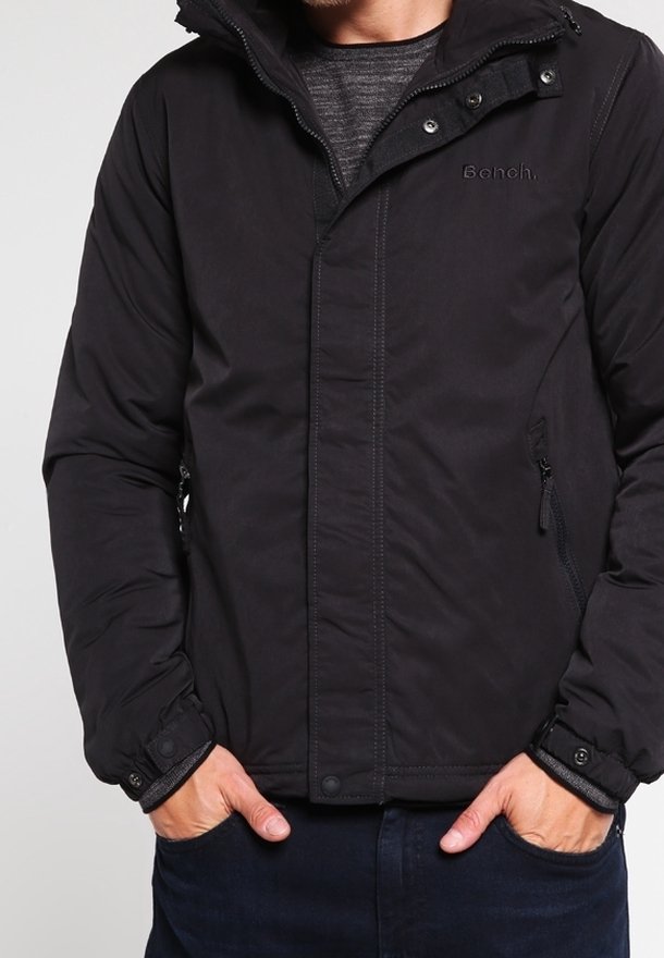Czarna pikowana kurtka z zamkiem błyskawicznym, zatrzaskami oraz bocznymi kieszeniami. Posiada kaptur oraz haftowane logo "Bench." na piersi.