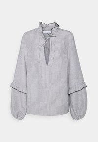 Blouse rayée blanche et marine, avec un col à volants, une fermeture à nouer, et des manches bouffantes avec détails aux poignets. Tissu doux et texturé.