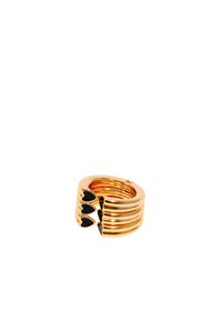 Anillo en tono dorado con bandas apiladas y estriadas, adornado con tres acentos en forma de corazón negro. Textura suave, diseño circular, abierto en la parte posterior.