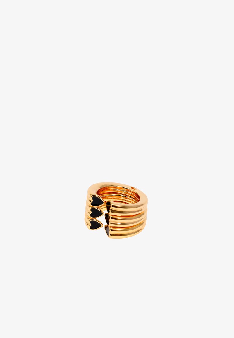Anillo en tono dorado con bandas apiladas y estriadas, adornado con tres acentos en forma de corazón negro. Textura suave, diseño circular, abierto en la parte posterior.
