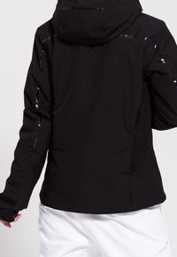 Svart teknisk jacka med huva, med reflekterande detaljer, texturerade paneler och åtsittande ärmar. Slät yta, skräddarsydd design.