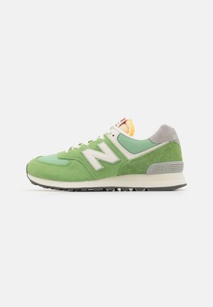 Green athletic shoe with suede and mesh materials. Features a white "N" logo, gray accents, and a textured rubber sole for grip.