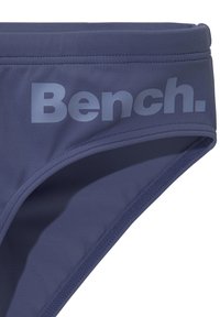Navy-blaue Bikiniunterteile aus dehnbarem Stoff mit Flachnähten und einem großen, tonalen "Bench."-Logo auf der Vorderseite.