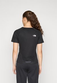 Μαύρο αθλητικό μπλουζάκι κοντό μανίκι με εφαρμοστή γραμμή, υφάσματα με υφή και μικρό λευκό λογότυπο στο πάνω πίσω μέρος. Απλό, λειτουργικό και κομψό.