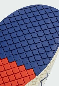 Guma podrážky s textúrovaným vzorom. Hlavné farby sú modrá a červená, s štvorcovými výrezmi pre lepší grip. Okraj je biely.