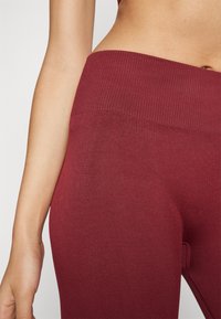 Leggings vișinii cu un talie înaltă cu nervuri, realizate dintr-un material elastic, având o textură netedă și o siluetă ajustată.