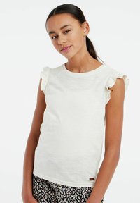 Hvid kortærmet skjorte med flagrende ærmekanter, lavet af et tekstureret stof. Har en rund halsudskæring og et lille brunt logo-tag i kanten.