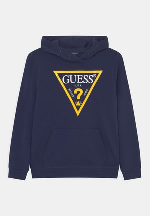 Marineblå hættetrøje med frontlomme og gult trekantslogo med teksten "GUESS U.S.A." med spørgsmålstegn og ordene "Washed Jeans".