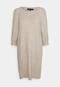 Beige stickad klänning med rund halsringning och trekvartsärmar. Löst sittande, mjuk textur och längd till mitten av vaden. Minimalistisk design utan mönster.