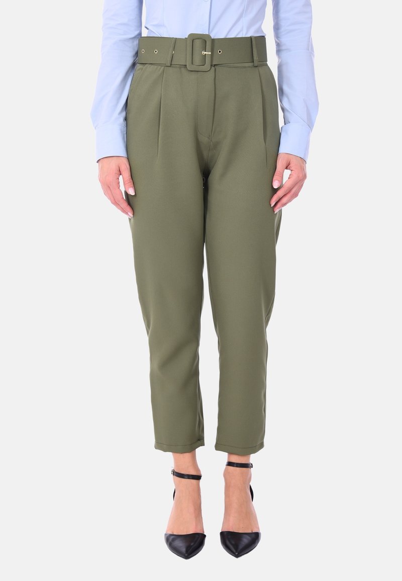 Pantaloni verde oliva a vita alta, dotati di una cintura con fibbia quadrata, con una parte anteriore plissettata e lunghezza croppata, abbinati a tacchi neri.