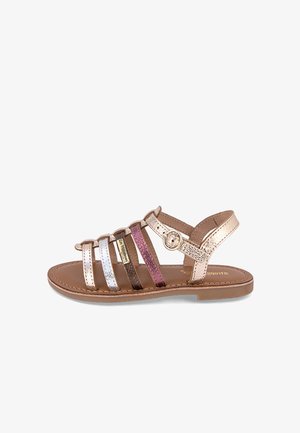 Sandalias de tiras con correas metálicas en dorado, plateado, rosa y púrpura. Suela plana con un detalle de hebilla redonda en la correa del tobillo.