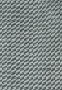 Helle blaue Stoff mit diagonaler gerippter Textur, die feine Linien und eine glatte Oberfläche zeigt. Geeignet für Polsterung oder Bekleidung.