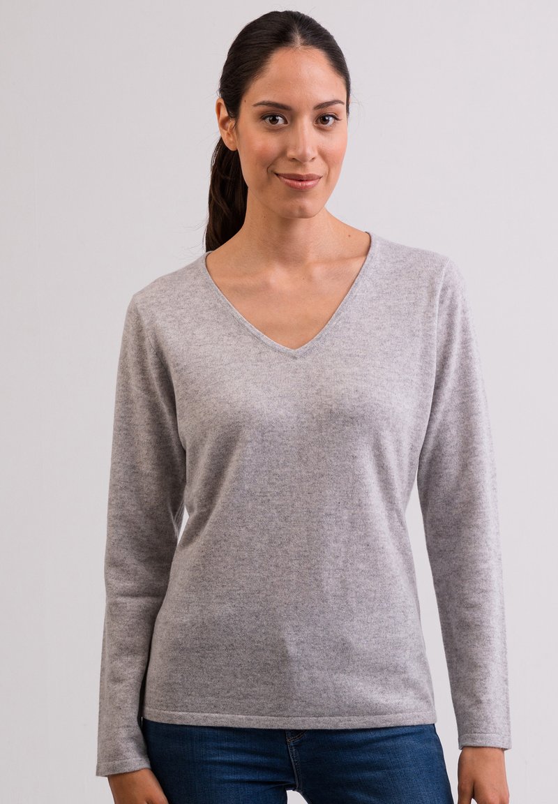 Maglione grigio a V con maniche lunghe, realizzato in un morbido materiale lavorato a maglia. Caratterizzato da una trama liscia e una vestibilità comoda. Abbinato a jeans blu.