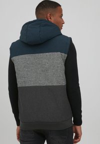 Kapuzenswester mit einem farbigen Blockdesign; oben in Dunkelblau, in der Mitte Hellgrau, unten Dunkelgrau; strukturierter Stoff und gerippter Saum.