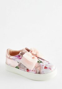 Różowy syntetyczny trampek z kwiatowym nadrukiem i metalicznymi akcentami, z dużą kokardą i białą gumową podeszwą.