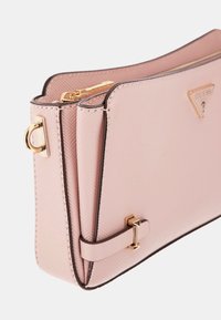 Borsa a tracolla rosa con texture, dotata di hardware dorato, presenta un logo triangolare, chiusura con zip e un design strutturato con rifiniture a contrasto.