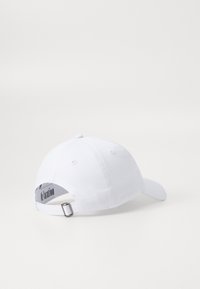 Fehér pamut baseball sapka ívelt karimával, állítható hátpánttal és logóval a belső részén. Simább textúrával és klasszikus dizájnnal rendelkezik.