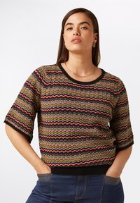 Gestickter kurzärmeliger Pullover mit einem mehrfarbigen wellenförmigen Muster in Grün, Rot und Schwarz sowie einem schwarzen gerippten Halsausschnitt und Bündchen.