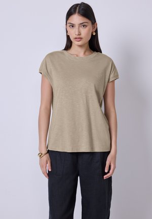 T-shirt à manches courtes couleur khaki avec une coupe décontractée, un col rond et une texture douce. Associé à un pantalon sombre et ample.