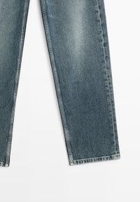 Jeans aus Denim in mittlerem Blauton mit geradem Schnitt, ausgestattet mit einer verblassten Textur und Standardnähten entlang der Nähte und Säume.