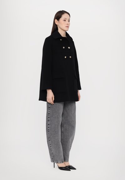 Black wool-blend coat with a collar, double-breasted gold buttons, and two front pockets. Worn over gray wide-leg jeans and black heels.