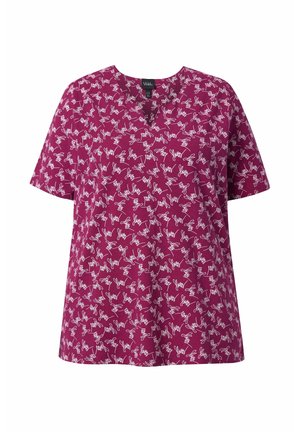 Blusa a maniche corte magenta con stampa astratta bianca a scarabocchi e scollo tondo, mostrata su sfondo bianco.