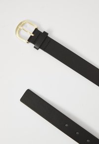 Ceinture en cuir noir avec une boucle en métal doré, présentant une texture lisse et plusieurs trous pour l'ajustement. Design simple et classique.