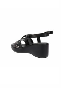 Sandali wedge neri con tomaia in tessuto testurizzato, dotati di cinturini incrociati e soletta imbottita per il massimo comfort.