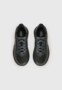 Chaussures de sport noires et grises avec une tige en mesh, des lacets ton sur ton, un col rembourré et une semelle en caoutchouc avec un motif texturé.
