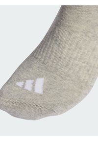 Calcetín gris de algodón con textura acanalada, punta reforzada y tres rayas blancas en el costado.