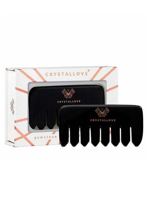 Schwarzer Haarkamm mit sechs langen Zähnen, untergebracht in einer weißen Box mit roségoldenen Akzenten und geometrischen Mustern. Markennamen deutlich sichtbar.