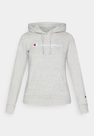 Lys grå hettegenser laget av myk stoff; har en frontlomme, justerbar snorhette, og brodert "Champion"-logo i blått og rødt.