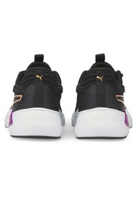 Sorte atletiksko med tekstureret overdel, hvid sål, gyldne detaljer og lilla markering på hælen. To trækstropper bagpå.