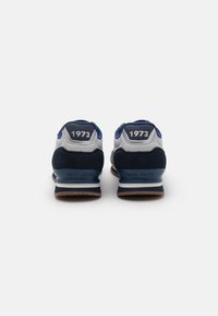 Blue and gray sneakers with a suede and mesh upper, featuring a cushioned sole, a stitched logo, and the number "1973" on the back.