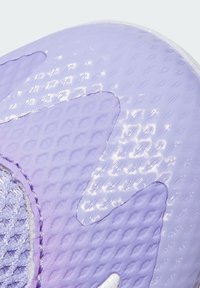 Nahaufnahme einer lila strukturierten synthetischen Schuhsohle mit weißen gedruckten Größen- und Herstellungsdetails.