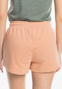 Perzik kleurige katoenen shorts met een elastische tailleband en naadloze randafwerking. Zachte textuur, ontworpen voor comfort en draaggemak.