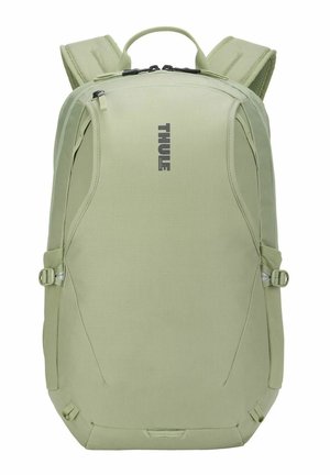 Sac à dos Thule vert clair avec bretelles rembourrées, poignée supérieure, fermetures éclair et sangles de compression latérales.