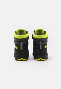 Baskets montantes noires avec un col rembourré, des accents jaune fluo et une surface texturée. Comprend un talon renforcé et des éléments réfléchissants.