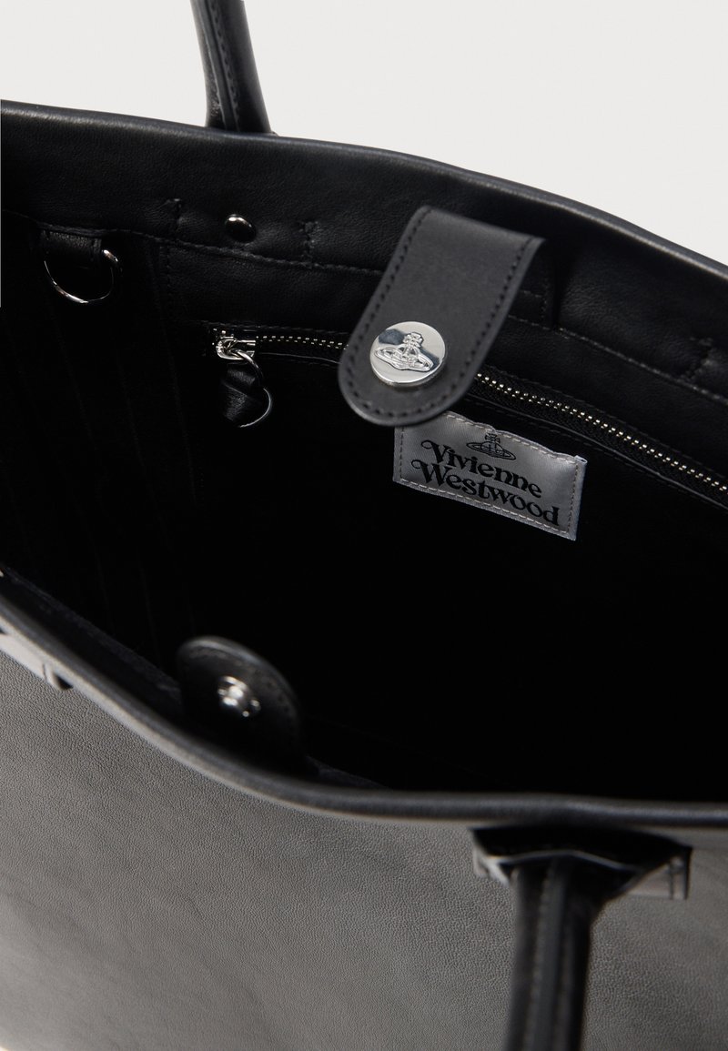 Black leather tote bag with a smooth texture, featuring a silver hardware zip pocket, and a logo label inside.