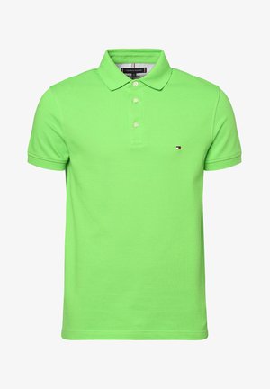 Helles grünes kurzärmliges Poloshirt mit Kragen, drei weißen Knöpfen und kleinem Tommy Hilfiger Logo auf der linken Brust.