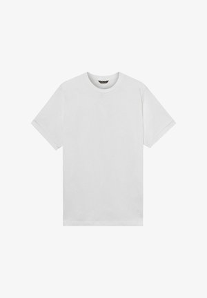 Effen wit T-shirt met korte mouwen en ronde hals, met een klein logo vlak bij de onderzoom, op een witte achtergrond.