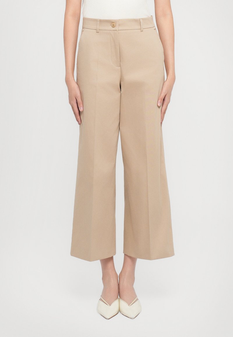 Beige Weitbein-Hosen aus glattem Stoff, mit einem Knopfverschluss vorne und Taschen, in taillierter Passform und mit klaren Linien.