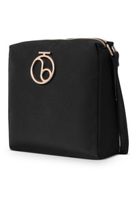Borsa a tracolla nera in nylon con un accento logo in tonalità oro, chiusura con zip e tracolla regolabile, caratterizzata da una texture liscia e opaca.