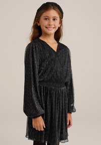 Svart plisserad klänning med långa ärmar och V-ringning, med en smockad midja och texturerad tyg, matchad med ett band.