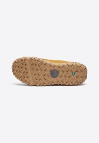 Suela de goma marrón con un patrón de tread multidireccional, que presenta un logo circular y un acento turquesa cerca del talón.