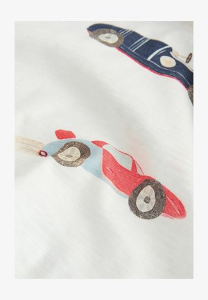 Dve hračkárske autá, jedno červeno-modré zrýchľujúce s čiarami pohybu, a jedno modré v staromódnom štýle, potlačené na bielom tkanive.