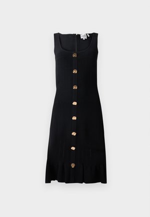 Mustmust ketidress, millel on jäik ülaosa, kuldtoonides nupud esipool ja laineline alläär. Tagaküljel on lukuga sulgemine.