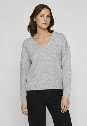Pull-over en tricot gris clair avec un col en V, épaules tombantes et poignets côtelés. Présente une finition douce et texturée ainsi qu'une coupe décontractée.