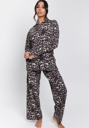 Leopard print loungewear set in soft fabric, featuring a zip-up long sleeve top and loose-fitting pants. Colors include black, cream, and brown.