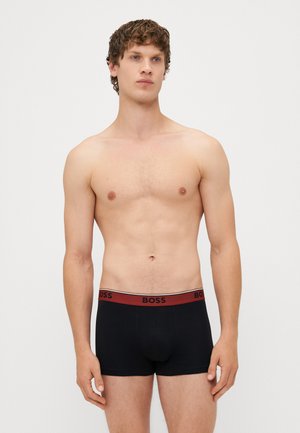 Zwarte boxershorts met een brede elastische tailleband met een rood "BOSS" logo. Gladde textuur, aansluitend ontwerp en lengte tot halverwege de dij.